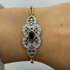 14K gold bracelet set with a central deep-blue Sapphire surrounded by sparkling Diamonds