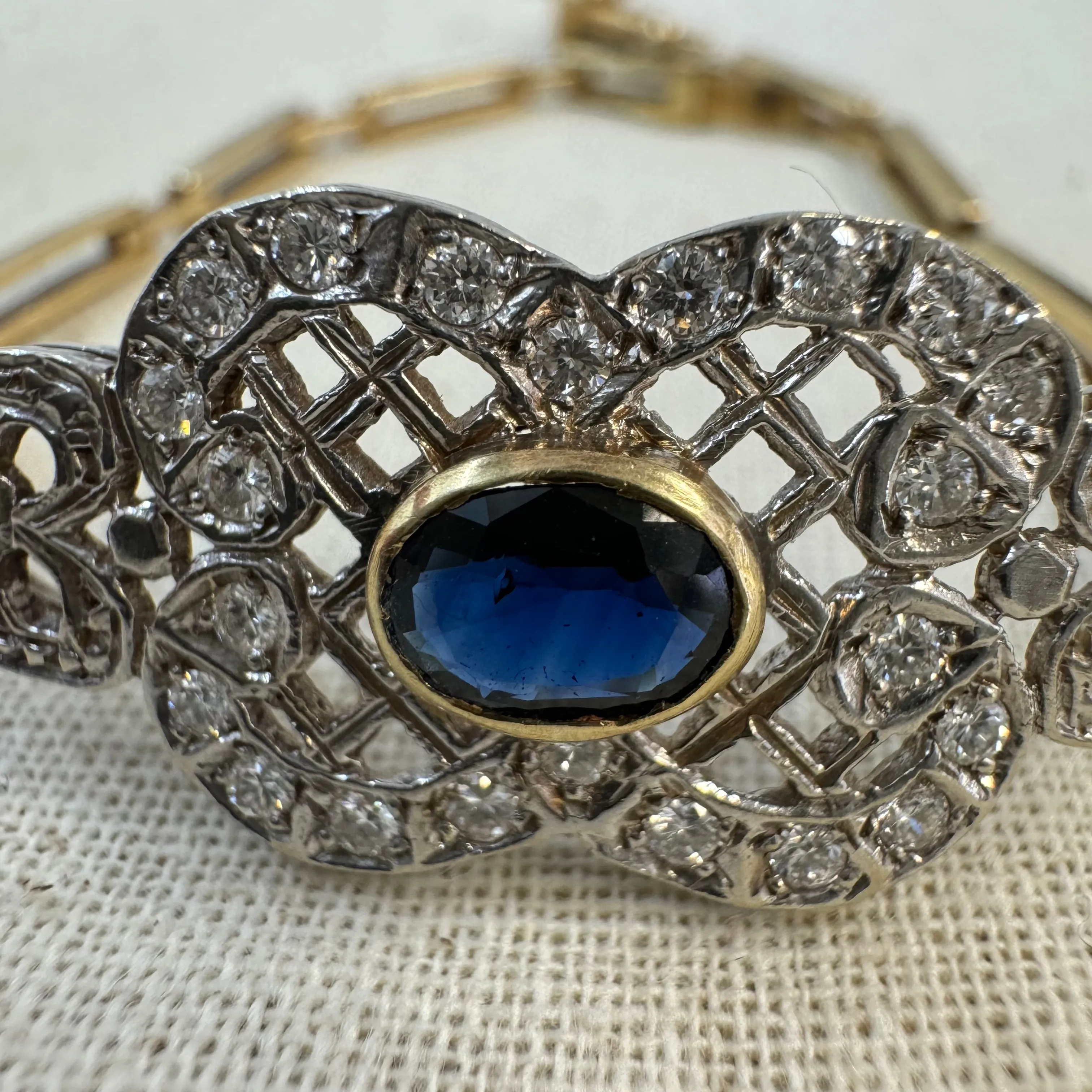 14K gold bracelet set with a central deep-blue Sapphire surrounded by sparkling Diamonds
