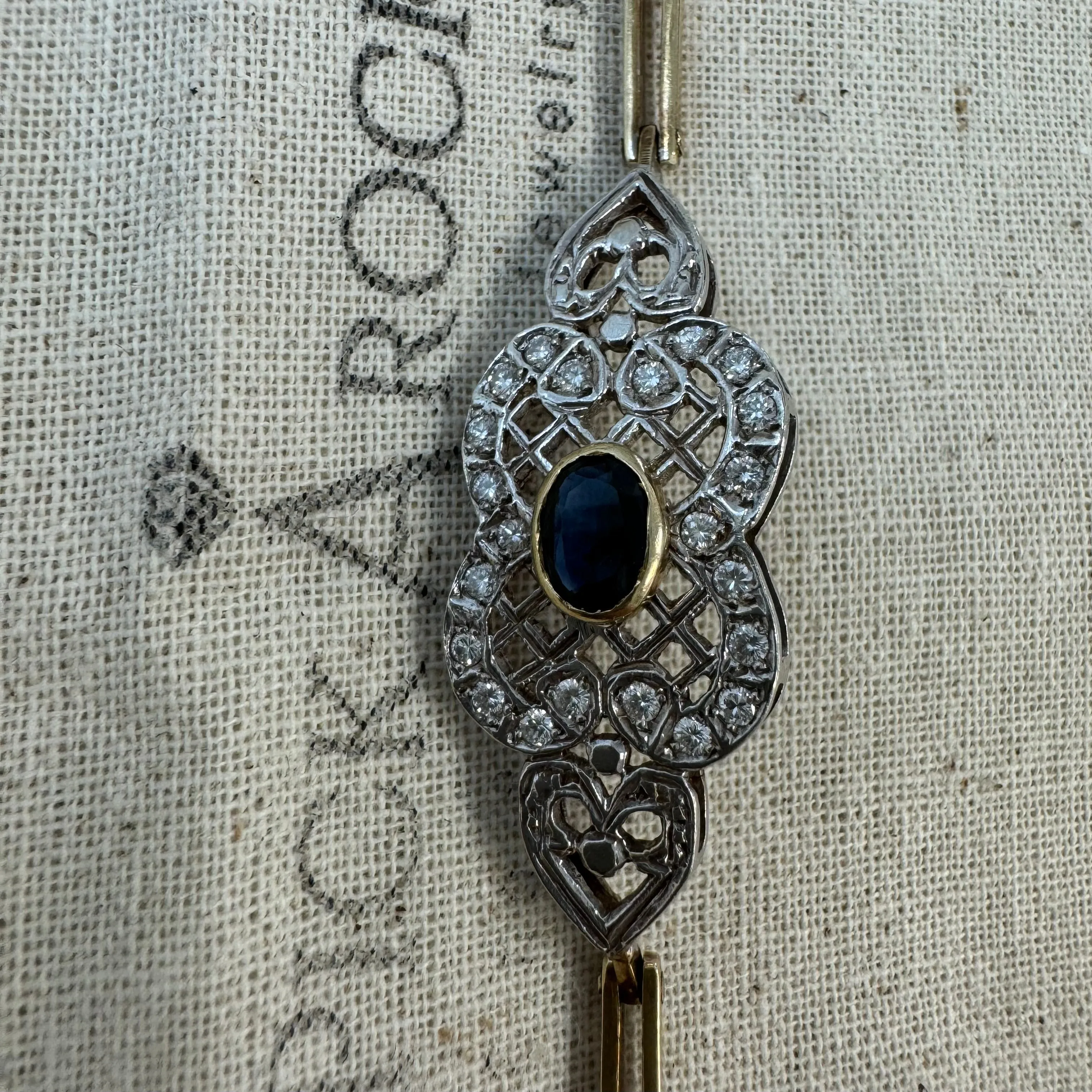 14K gold bracelet set with a central deep-blue Sapphire surrounded by sparkling Diamonds