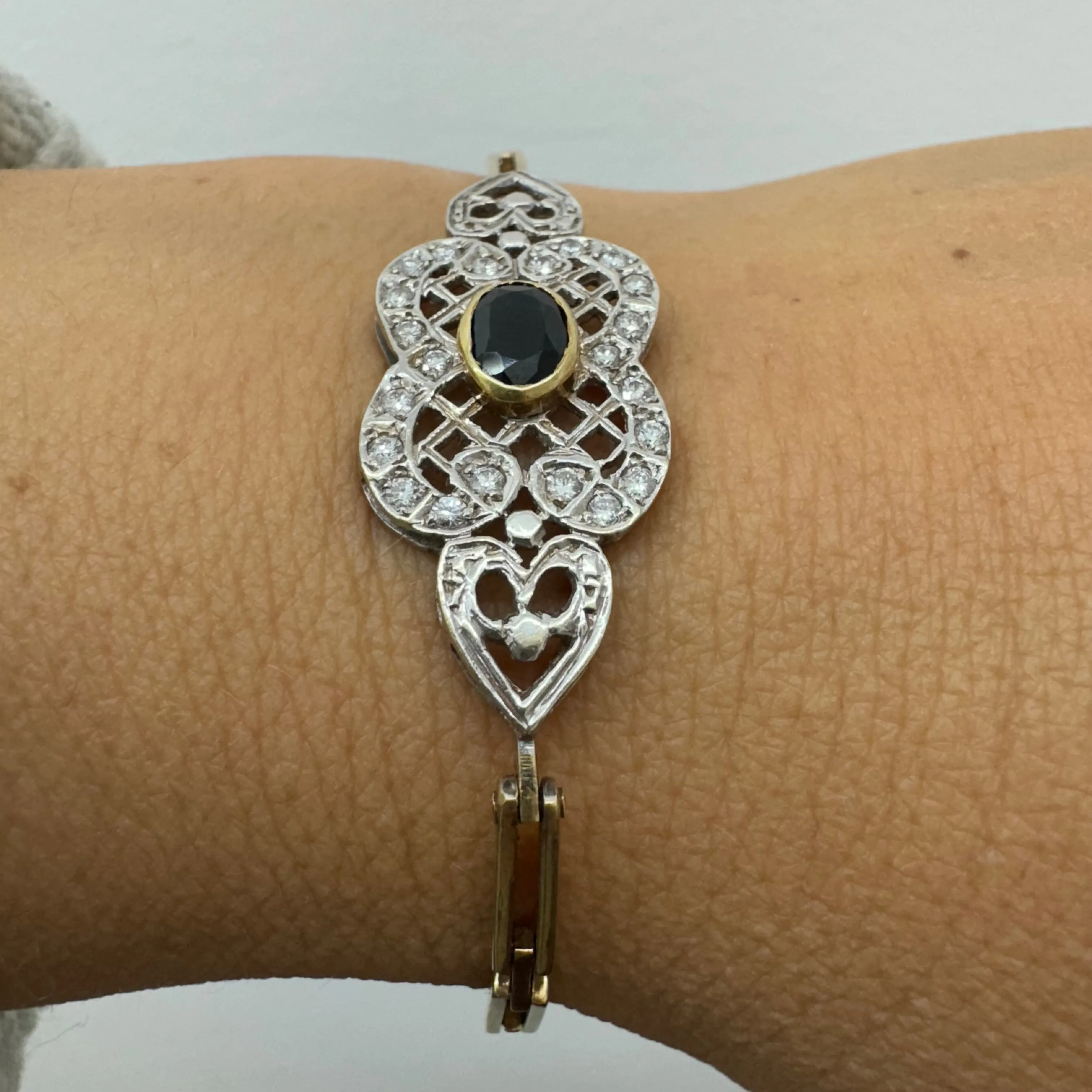 14K gold bracelet set with a central deep-blue Sapphire surrounded by sparkling Diamonds